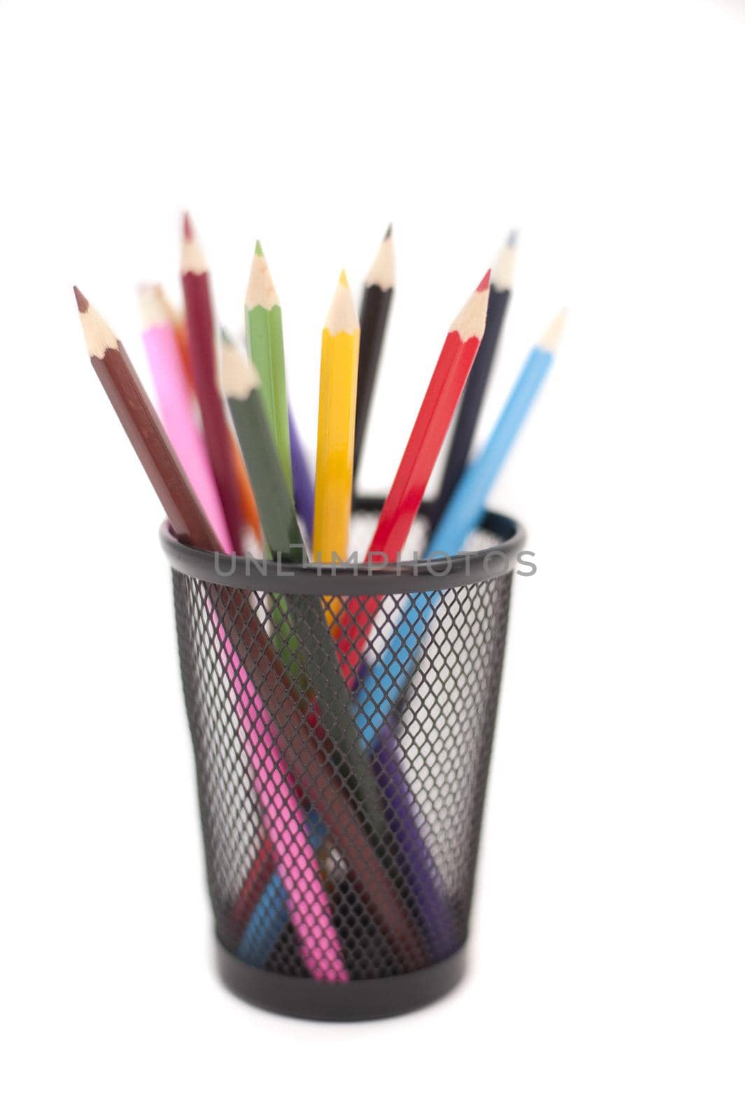 Colored pencils in black pencil holder isolated on white