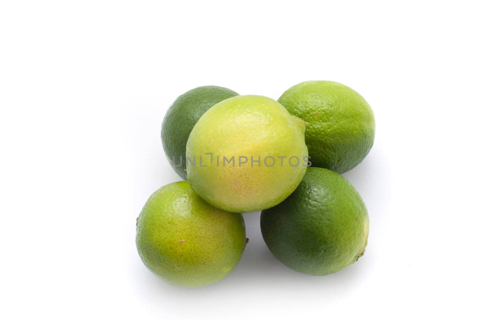 Overhead view of a stack of five fresh limes rich in vitamin c and used as a garnish and flavouring in cookery