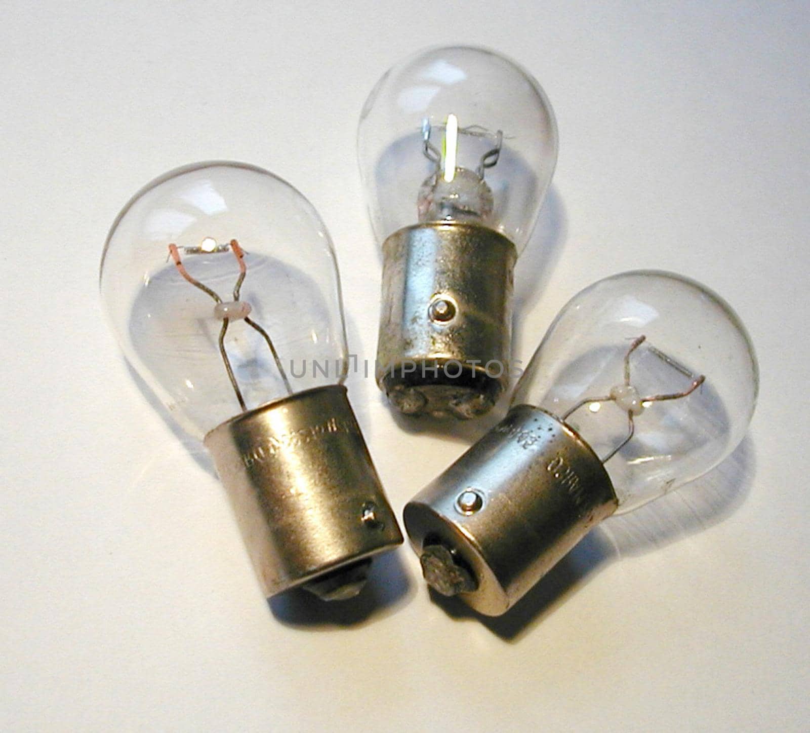 Close up on three small car lamps or globes on a white background for automotive themed concepts