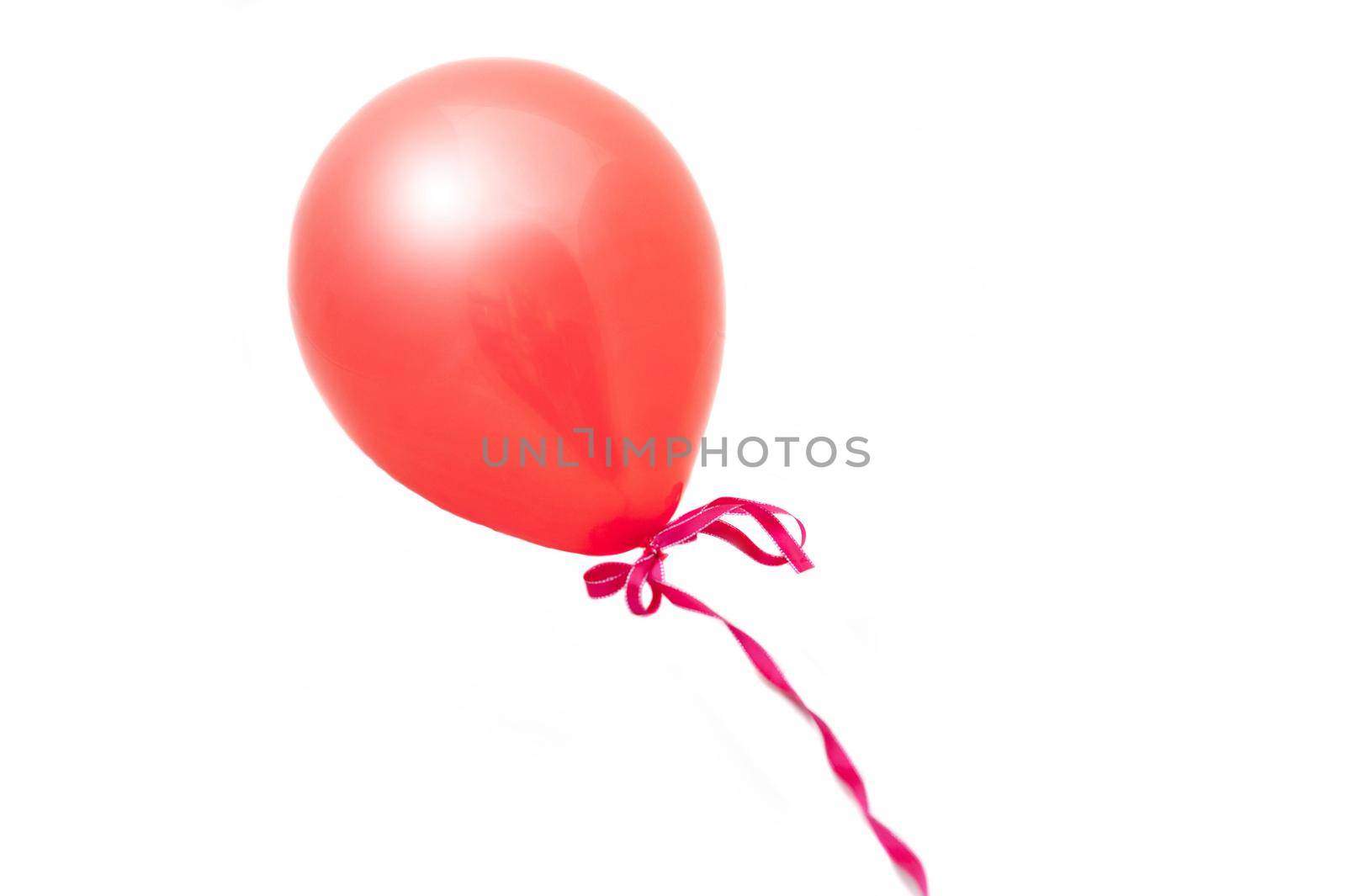 a red balloon tied with a pink ribbon cut out on white