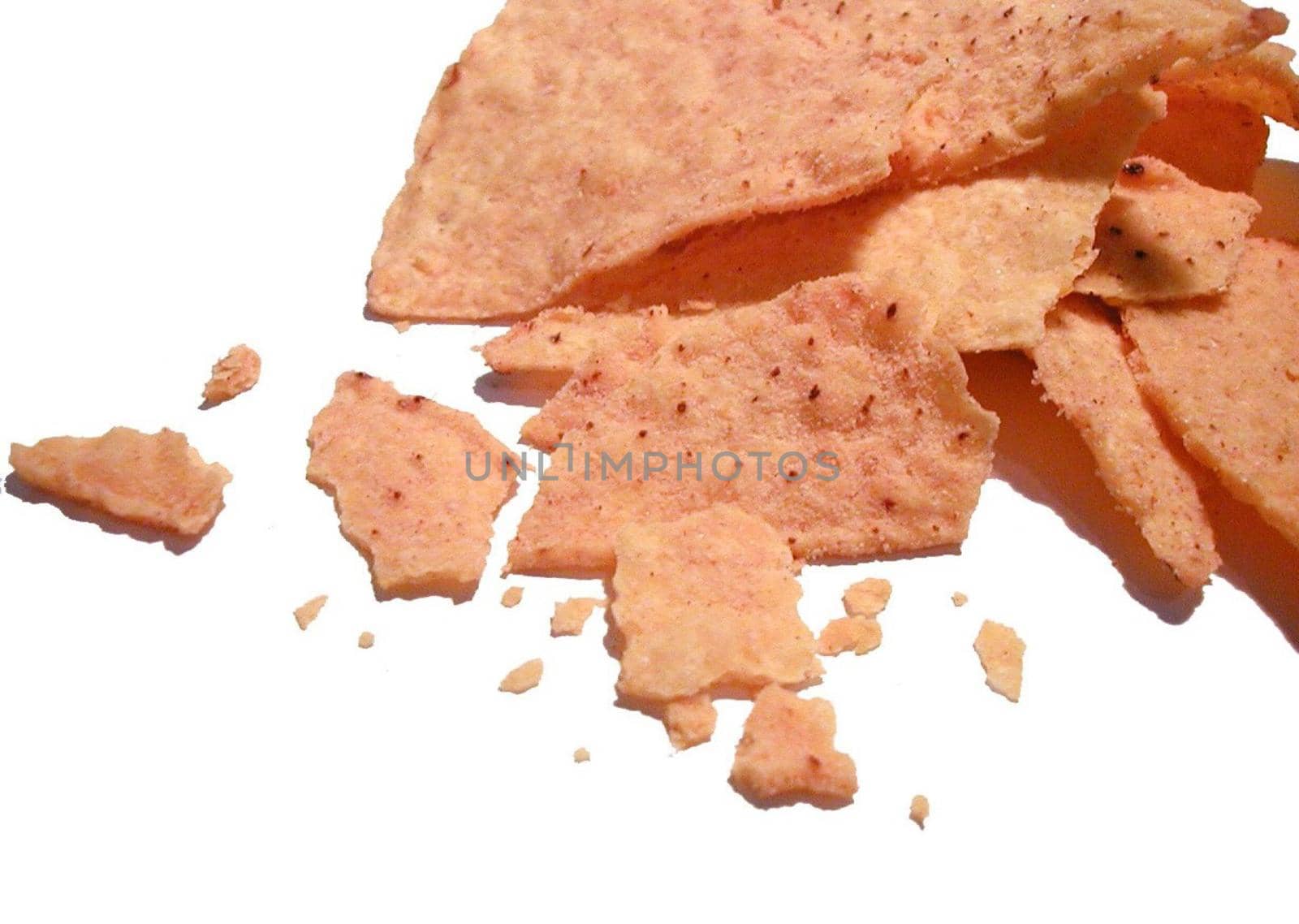 Closeup of a crushed potato crisp with seasoning scattered on a white background
