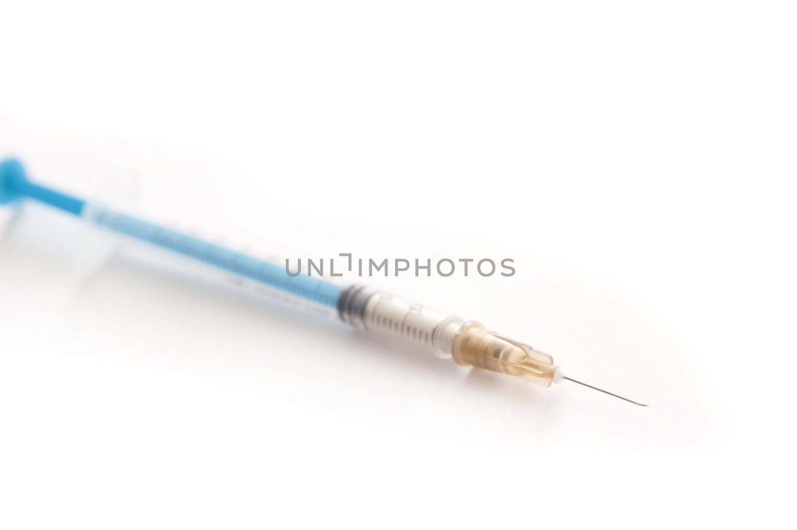 Small disposable plastic syringe or hypodermic with needle for administering medication subcutaneously in diseases such as diabetes, diagonally over white