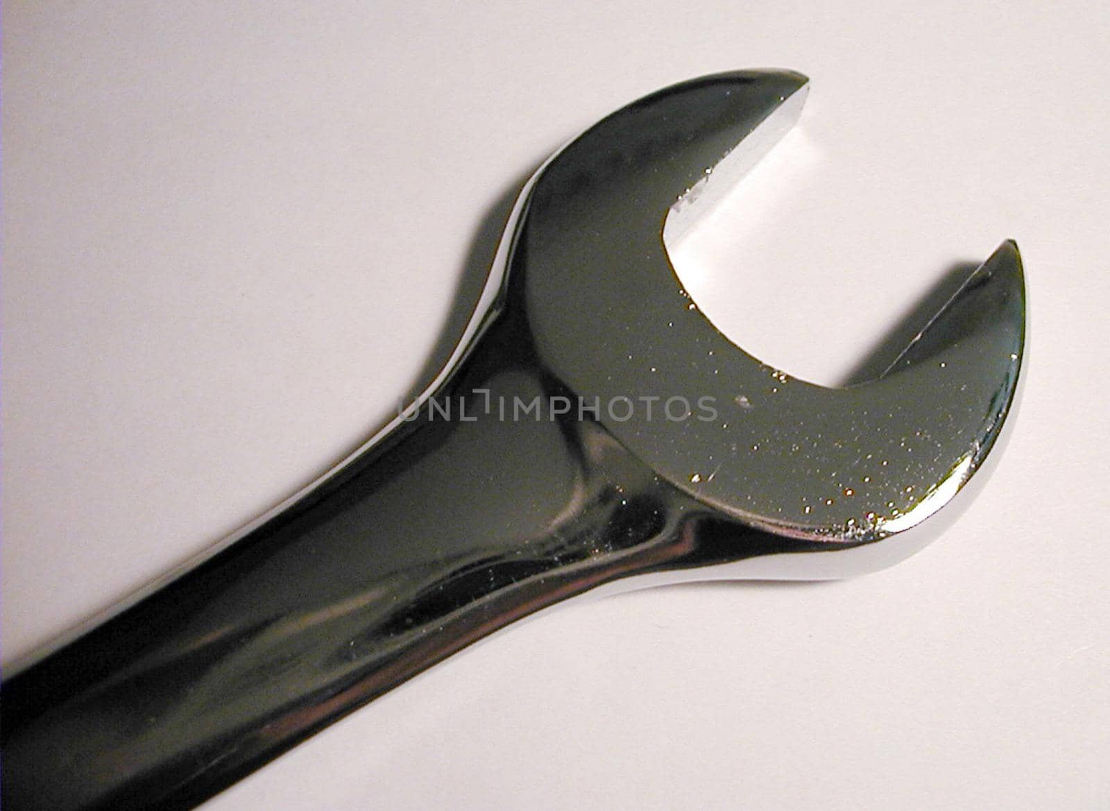 Close up detail of a steel spanner or wrench showing the jaws end for use on bolts and nuts over a light grey background