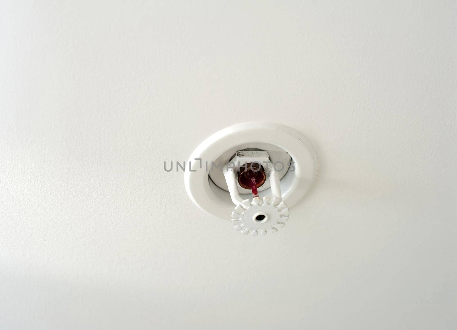 Ceiling mounted fire sprinkler which detects the increased heat from a fire and automatically sprays jets of water on the surroundings