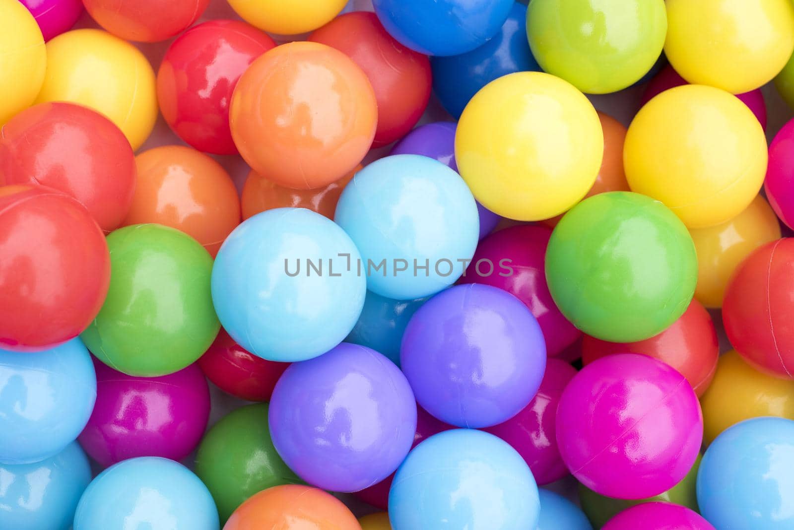 Background of a heap of colorful balls in rainbow colors in a full frame view from above