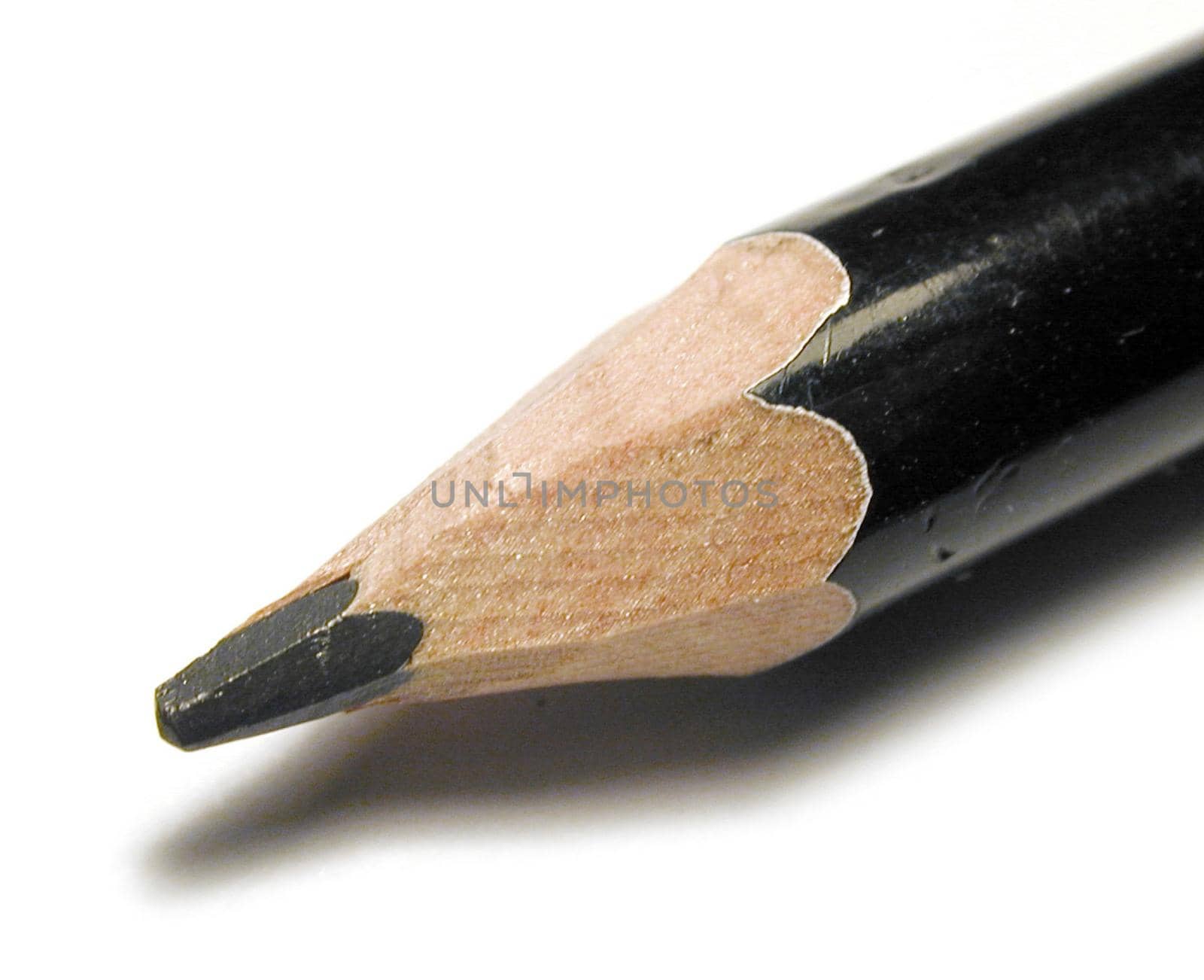 Sharpened black wooden pencil point in a close up macro view over white with shadow