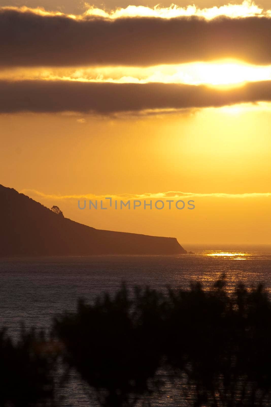 a beautiful golden yellow sunset over california big sur coastline