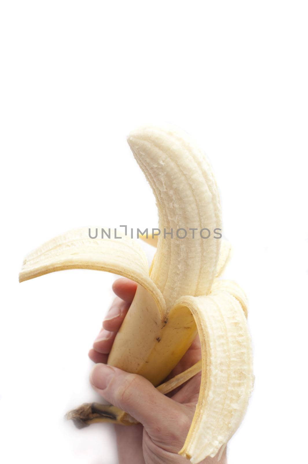 A hand holdng a peeled banana on white backdrop