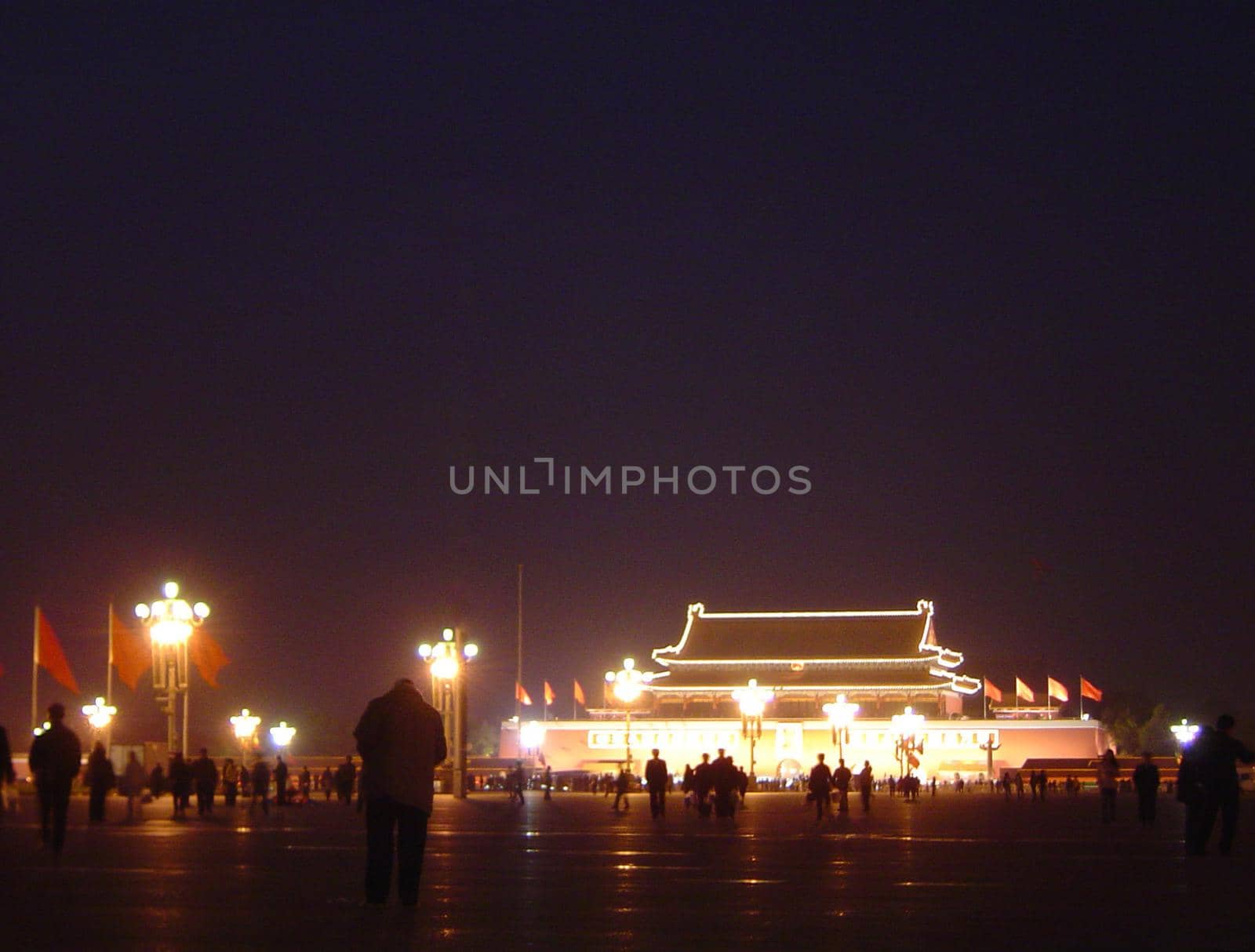 Silhouettes of Visitors in front of Illuminated Gate or Building in Forbidden City, Chinese Imperial Palace in Beijing, China