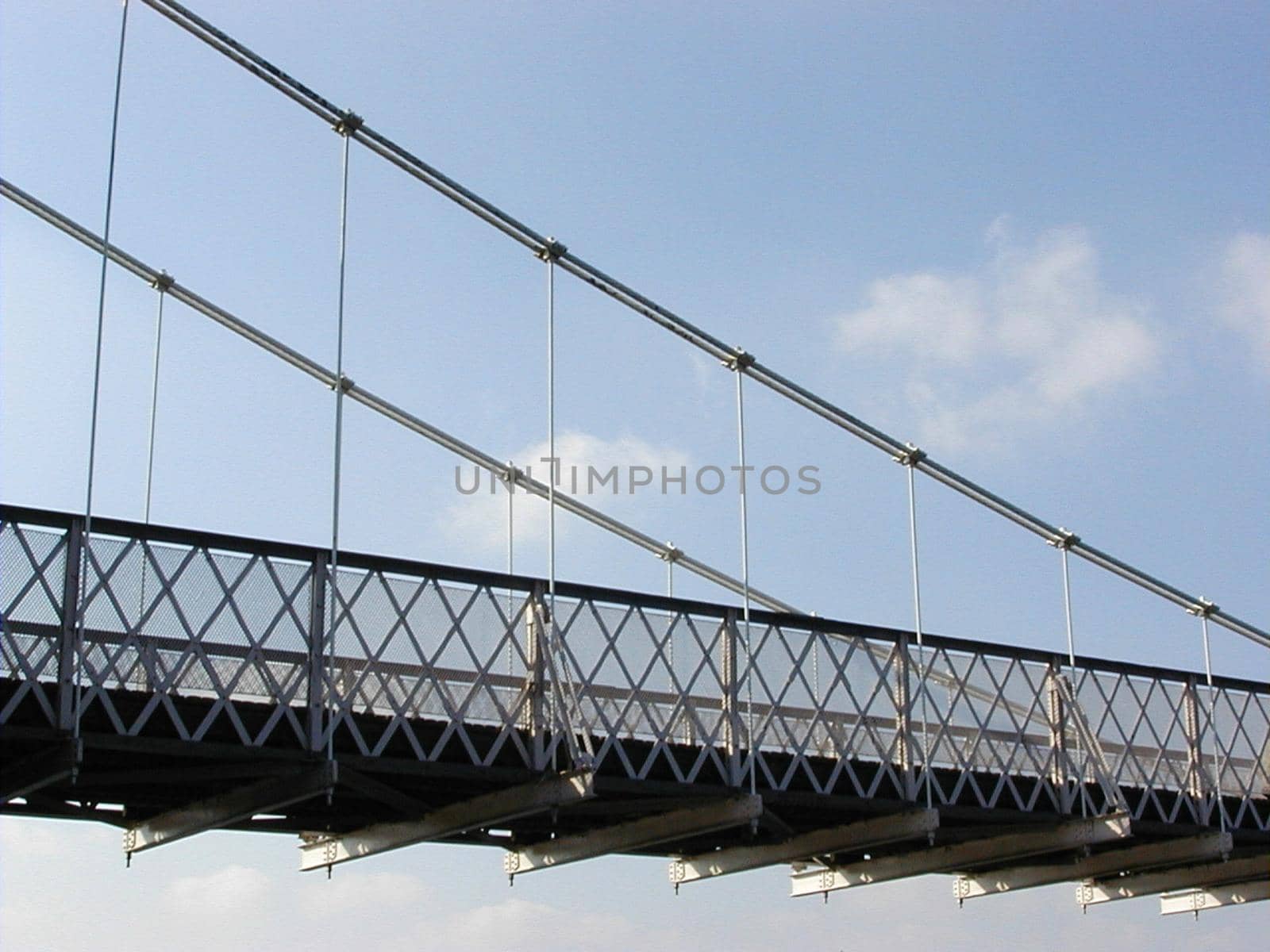 Suspension bridge deck in close-up from low angle against blue sky