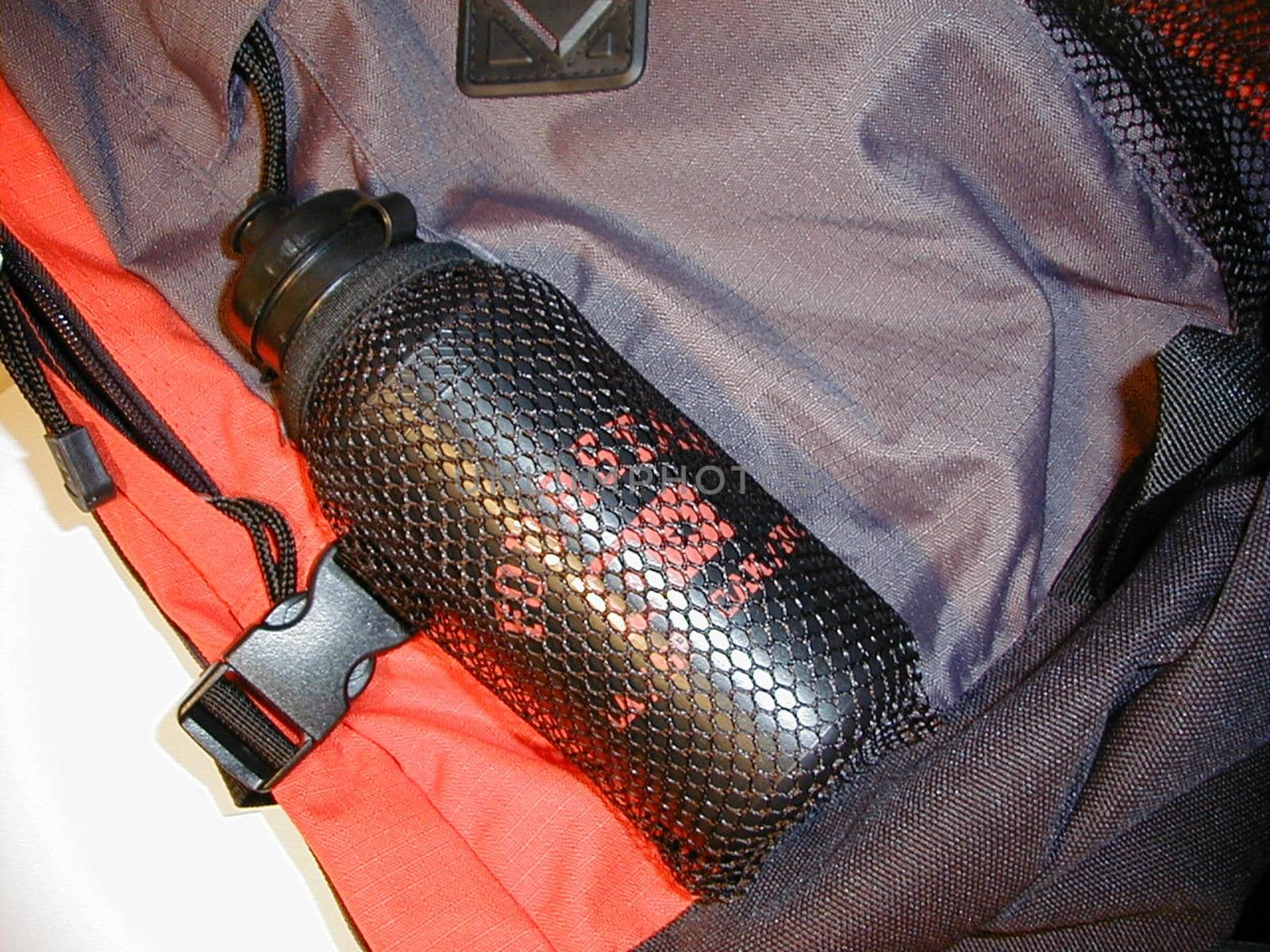 Open backpack with a plastic bottle for water or liquid refreshment lying in the compartment conceptual of a healthy outdoor lifestyle