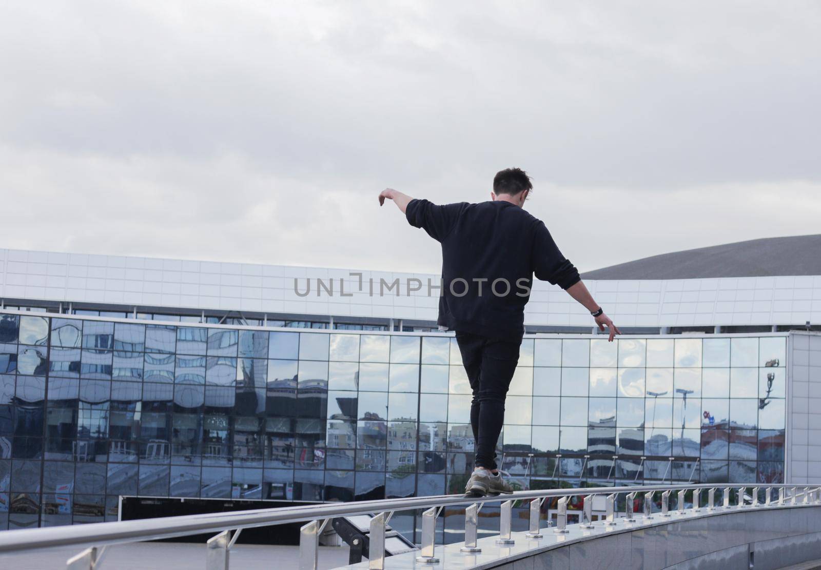 The guy walks along the railing at a height. by gelog67