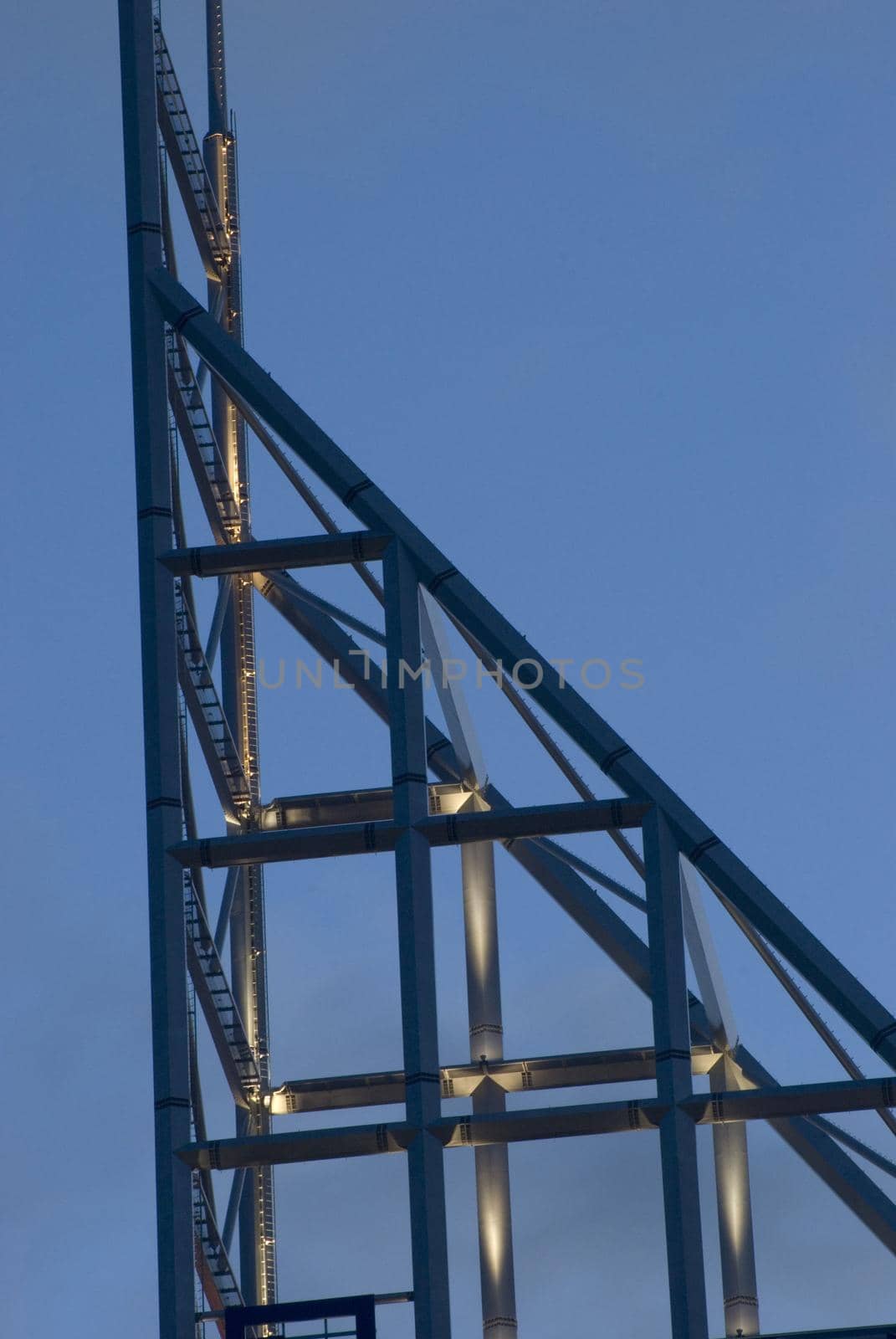 High-rise architecture metal building spire with an open-sided triangular design against a blue sky