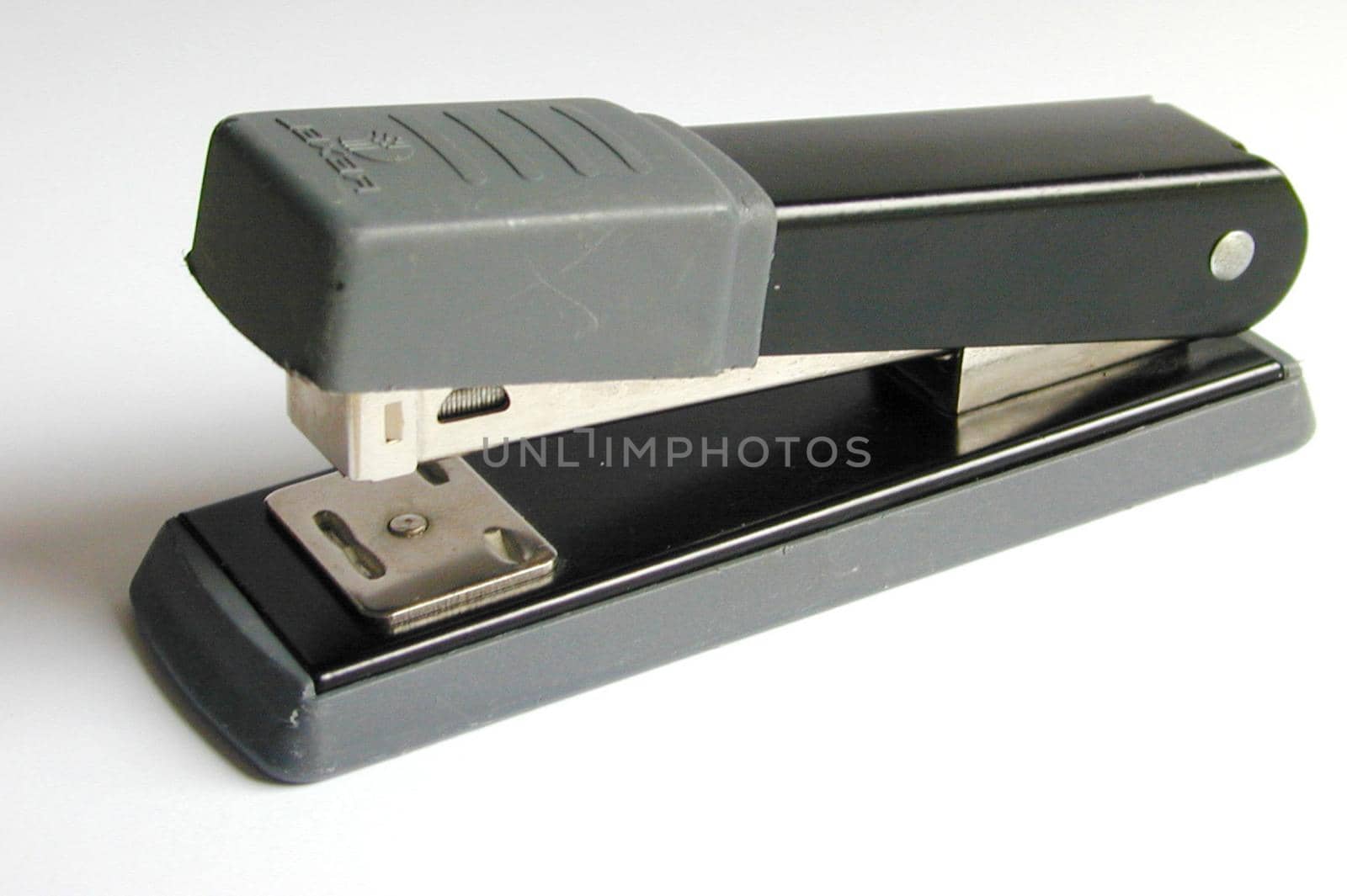 Plain black office stapler on a white background viewed from the side with copy space