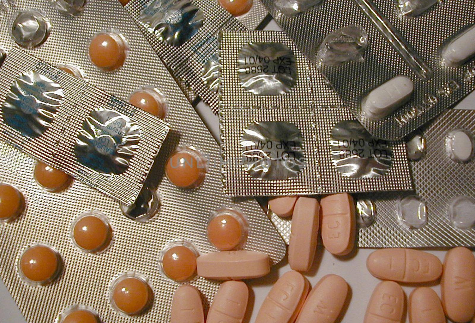 Medical background of assorted pills and capsules in a random pile, some in silver foil blister packs in a healthcare concept