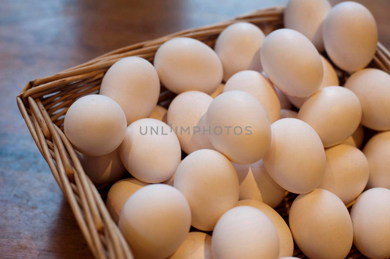 Farm fresh hens eggs displayed in a wicker basket at a farmers market for a healthy breakfast or to use as an ingredient in cooking and baking