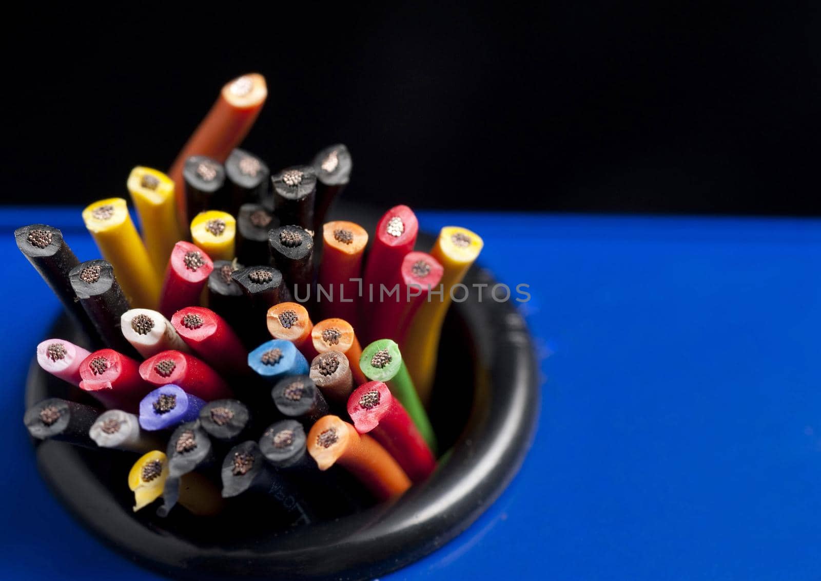 Bunch of severed wires with colorful plastic coatings in the colors of the rainbow viewed from above with copy space