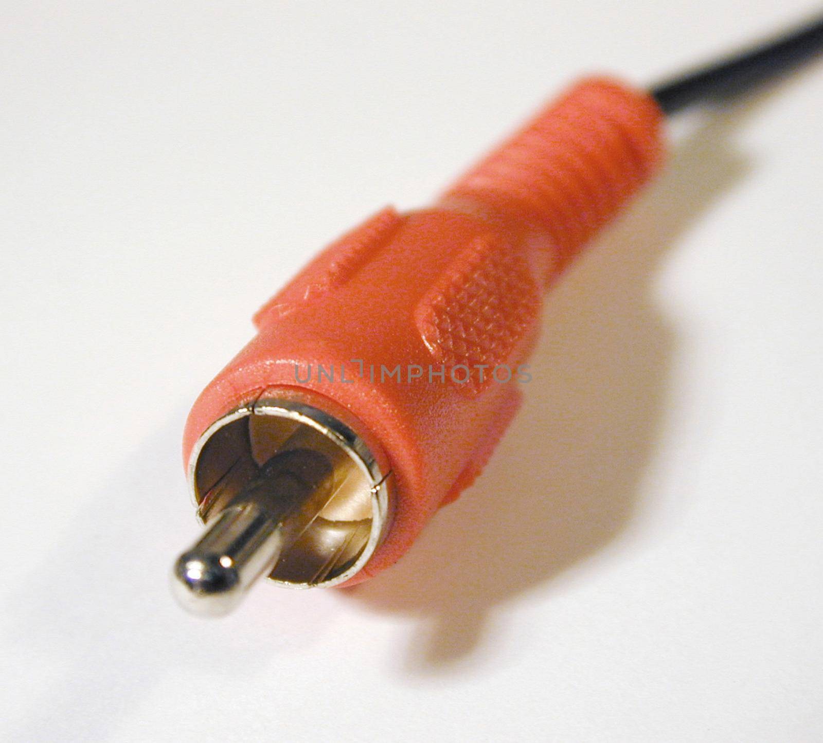 Close up of small orange metal and rubber electrical contact connecter attached to plastic black wire
