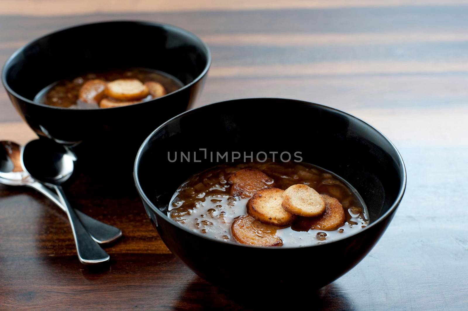 Crisp golden fried bread croutons floating in bowls of tasty brown French onion soup served as a starter or appetizer
