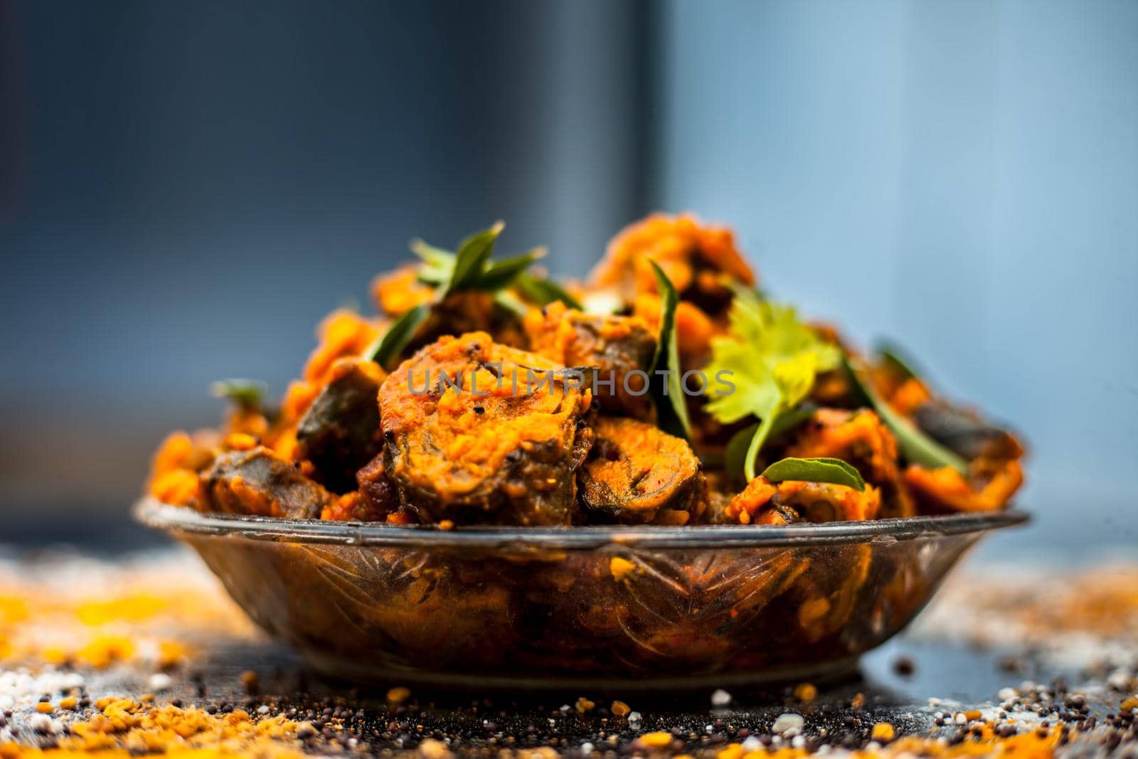 Famous Indian & Gujarati snack dish in a glass plate on wooden surface i.e. Patra or paatra consisting of mainly Colocasia esculenta or arbi ke pan or elephant ear leaves and spices. Horizontal shot. by mirzamlk