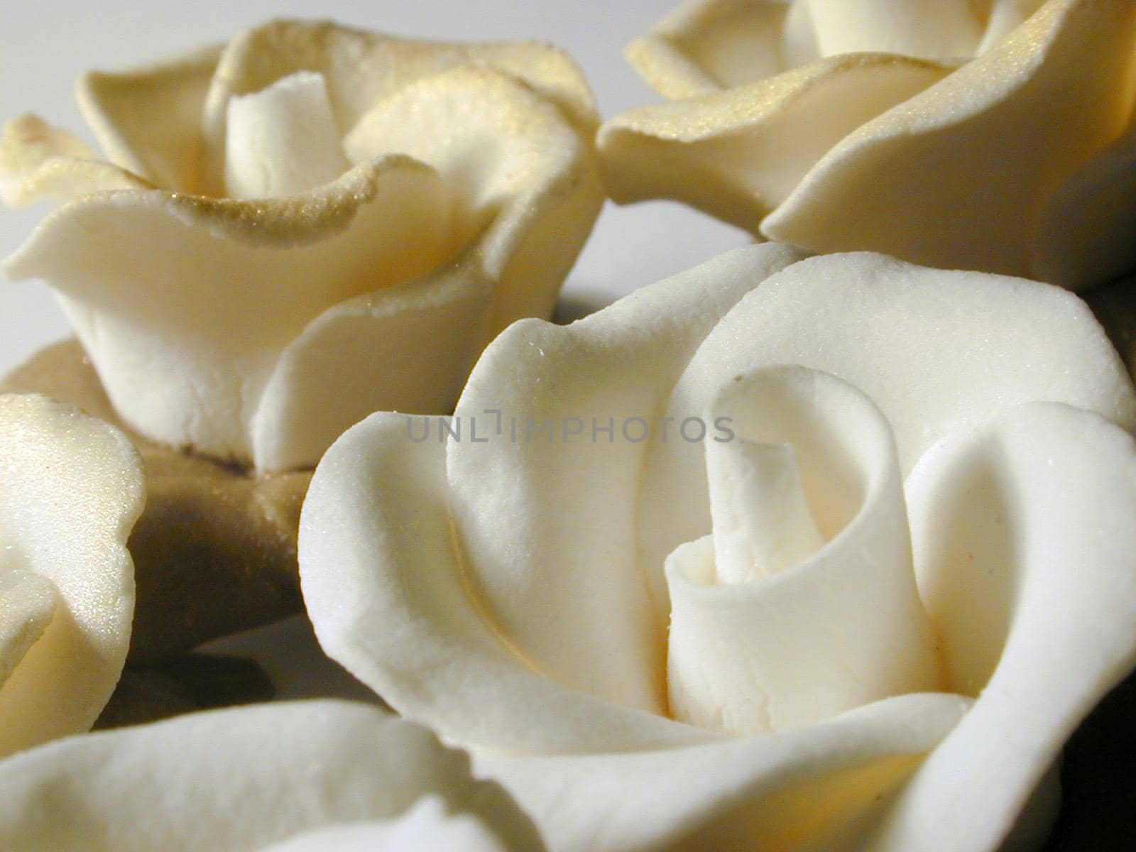 Close Up of Decorative Delicate White Icing Flower Roses Dusted in Gold Dust