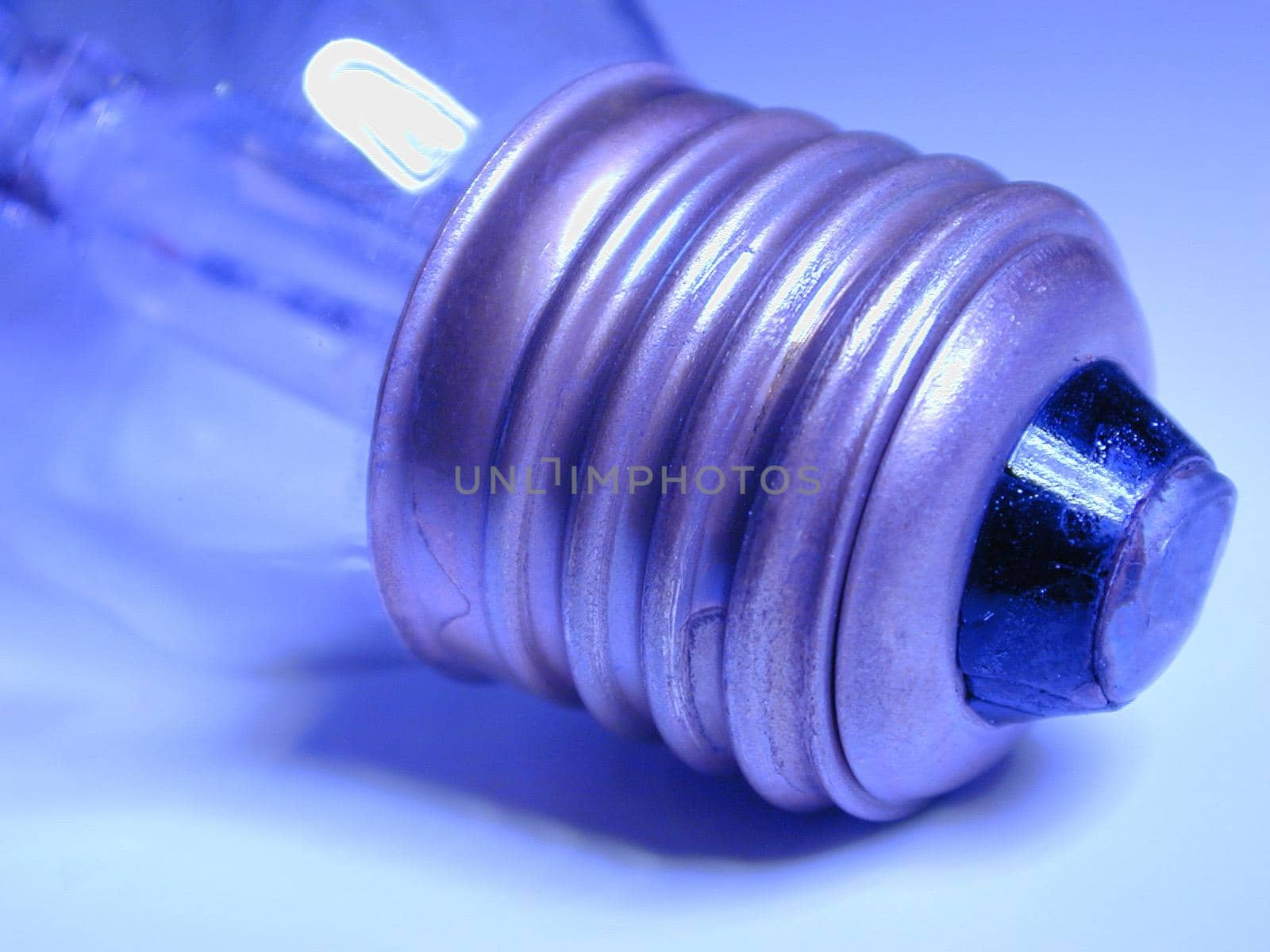 Screw fitting on an electric light bulb viewed close up on the threads in blue light in a power and energy concept