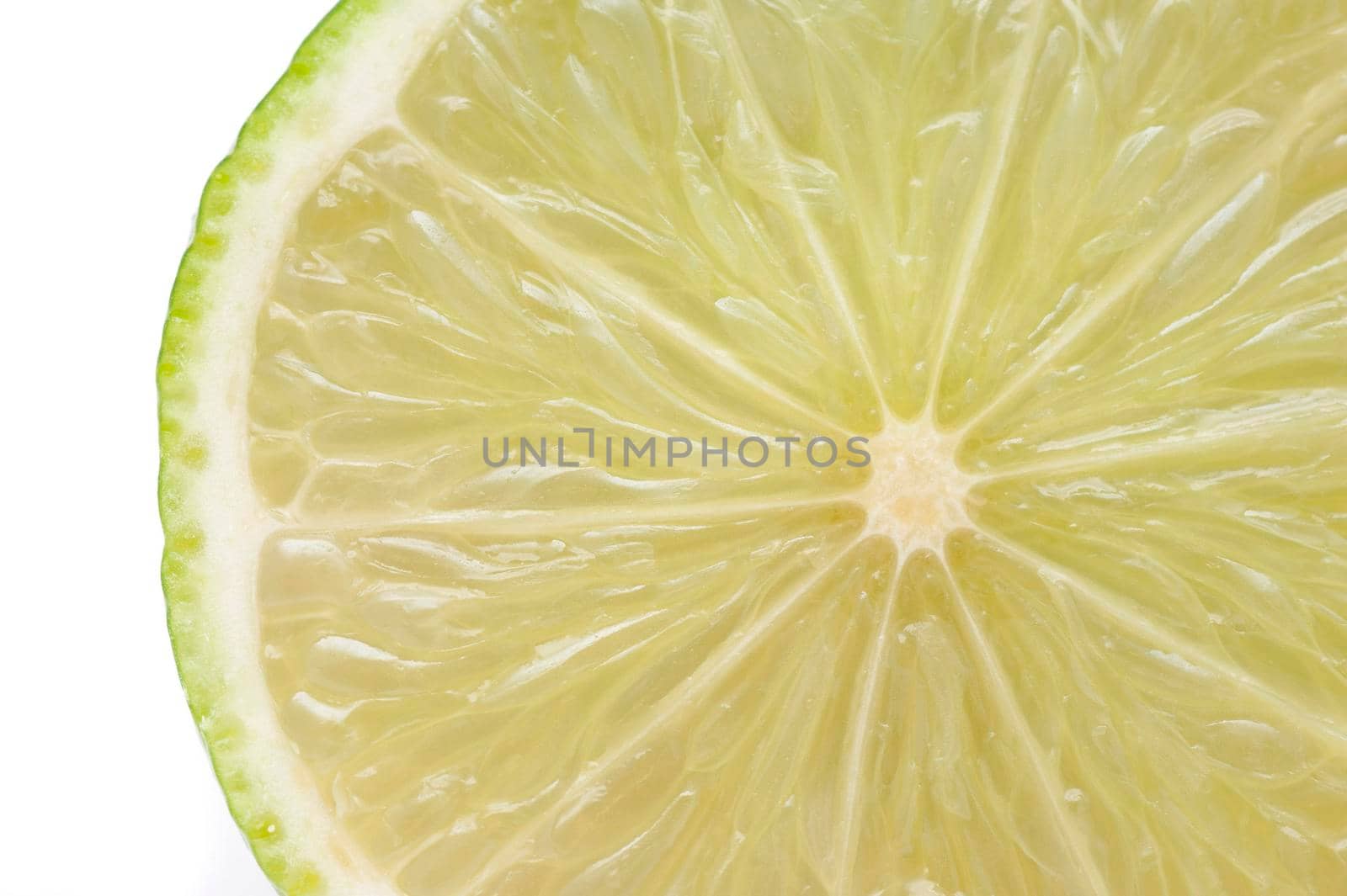 Close up texture of fresh sliced lime showing the juicy pulp, segments and thin bitter rind isolated in white