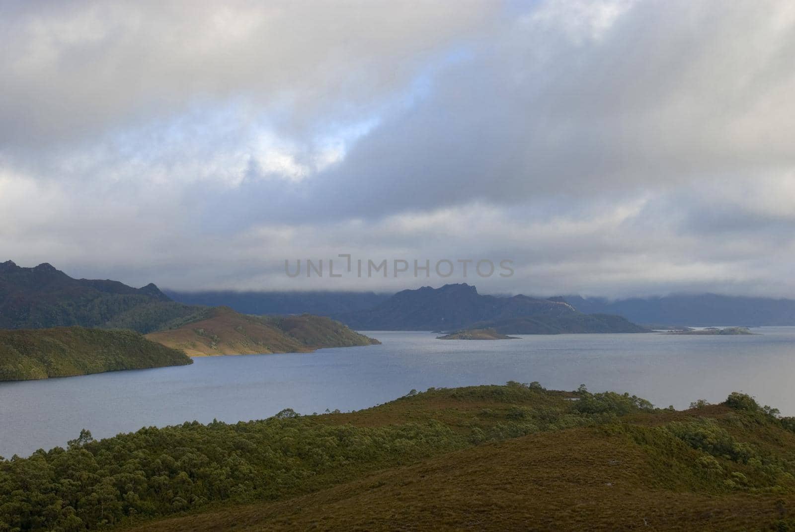 a panoramic view of lake pedder with dramatic storm clouds
