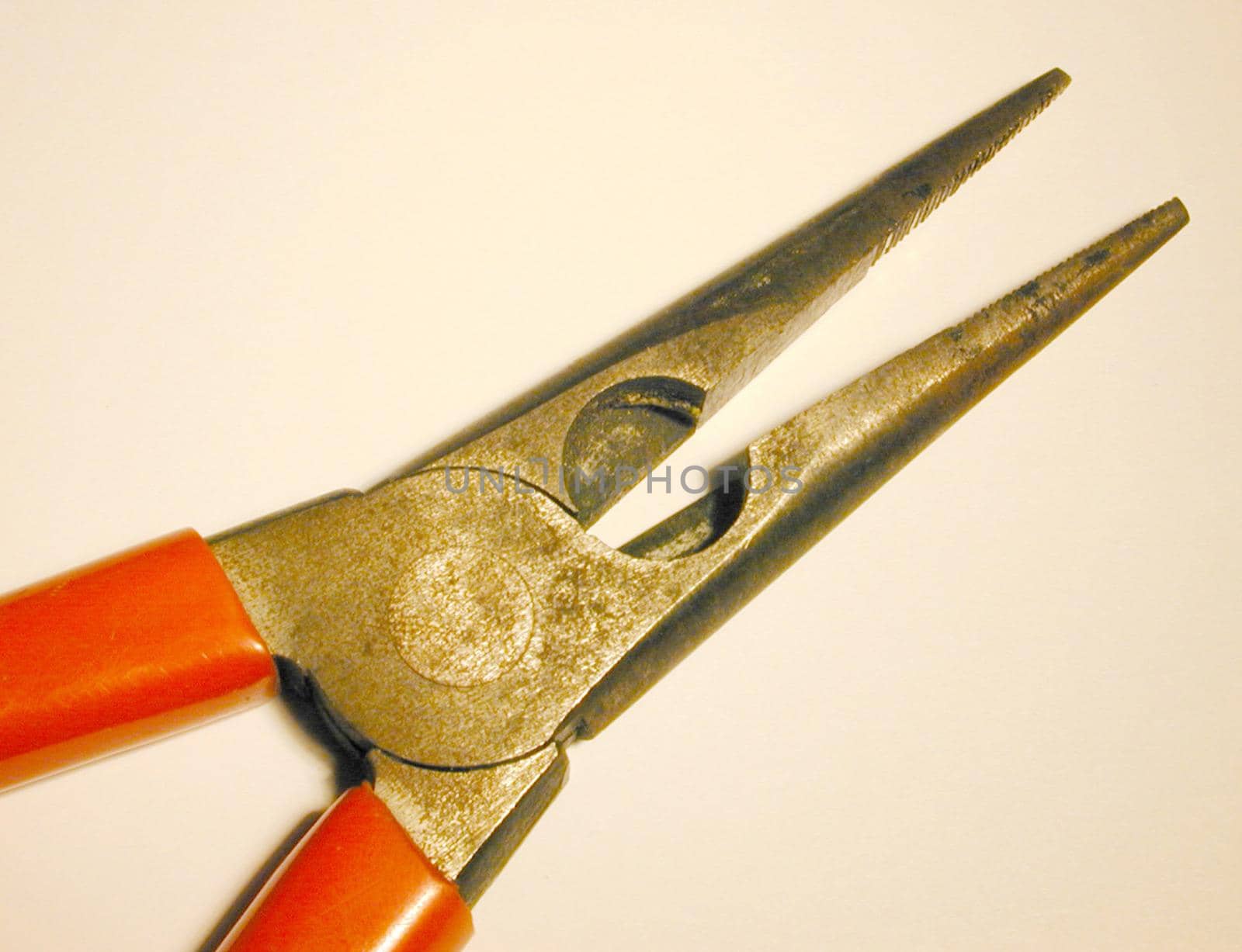 Pair of pliers with open jaws on white in a close up partial view from above