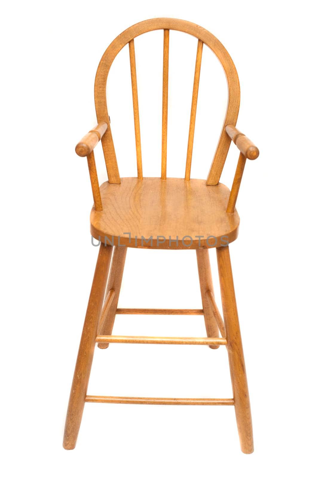 Wooden high chair used to feed a baby or toddler with a spindle back isolated on white