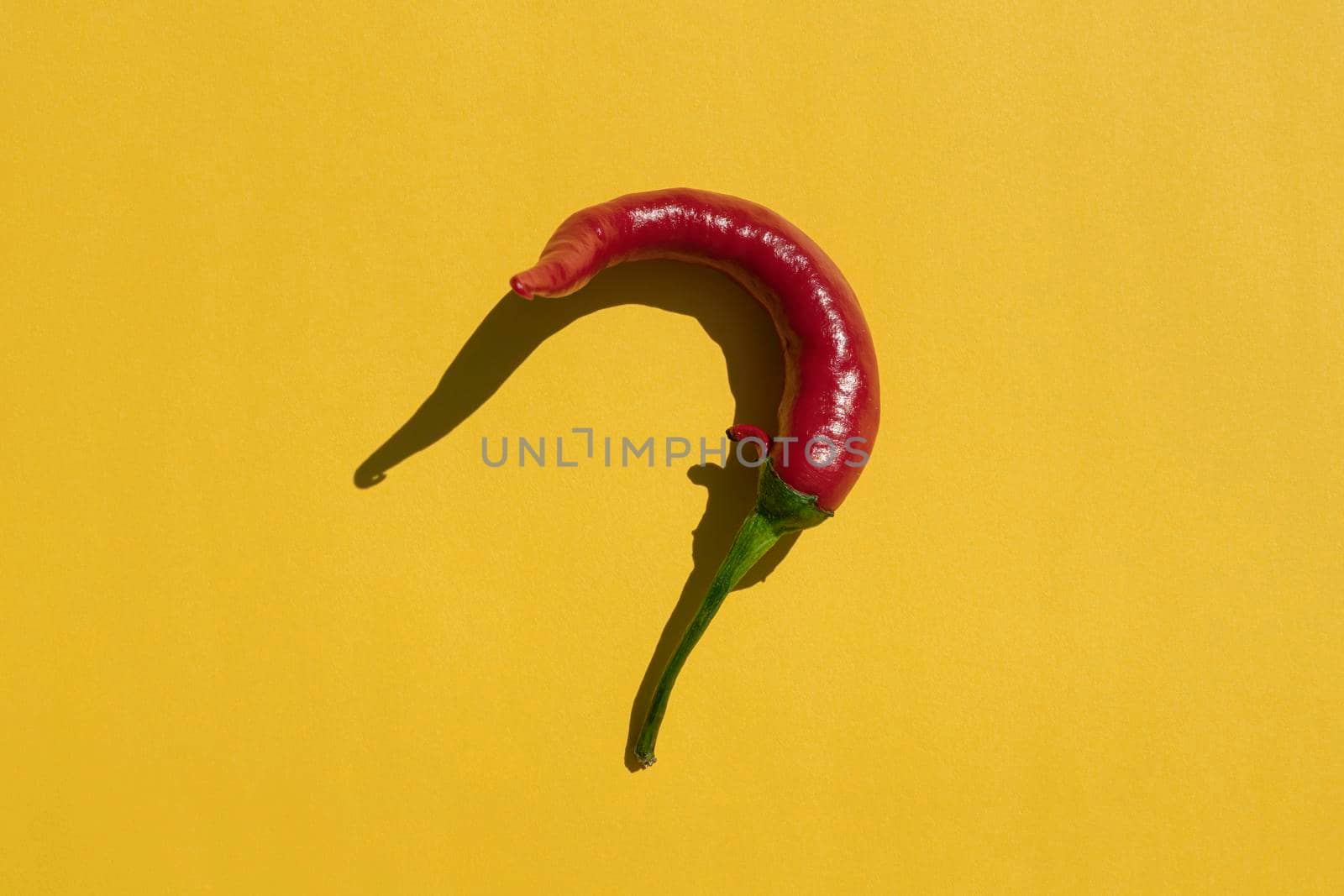 red hot pepper on a yellow background with a hard shadow. High quality photo