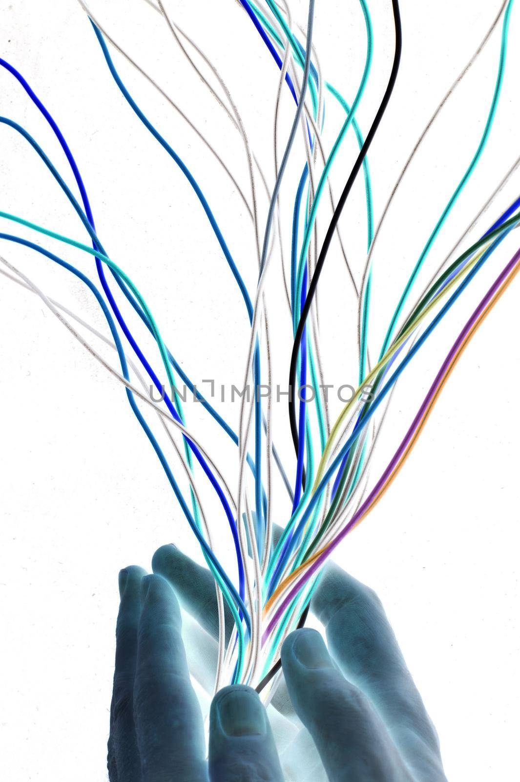 Artistic abstract with multicoloured electrical wires beign streamlined by cupped hands