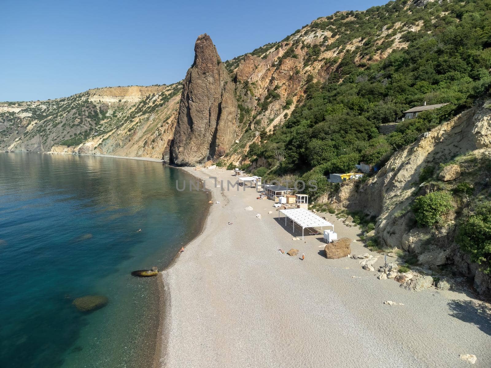 Sea landscape with rocky coastline on sunset time with cloudy sky. Yachts in the Sea on a background of rocky shores. The concept of perfect place for summer travel and rest.