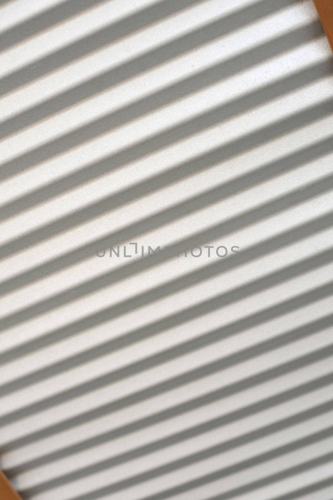 Corrugated metal sheeting with diagonal lines in a tilted view of cladding, a shutter or door in a full frame background texture and pattern