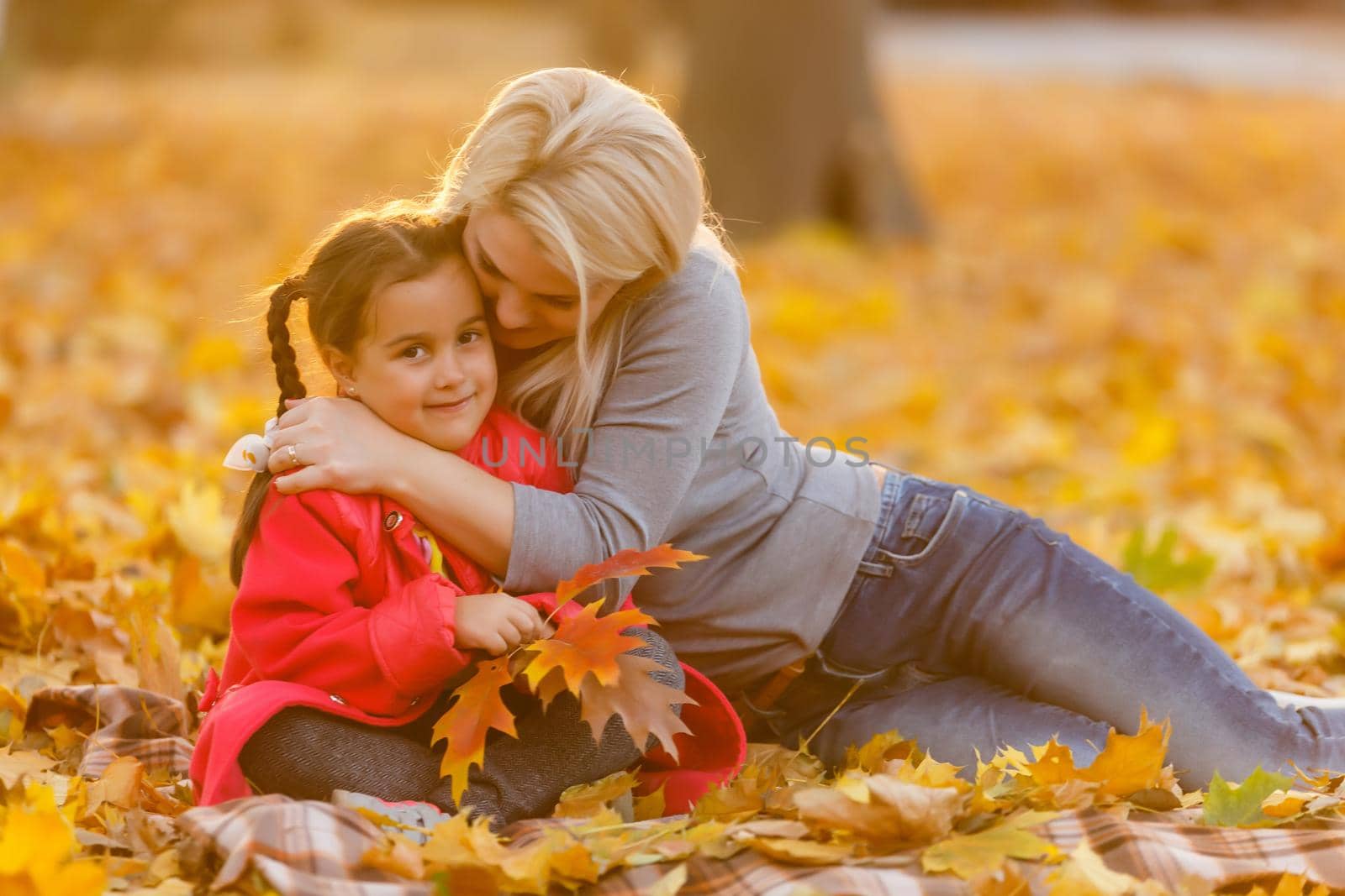 Mother with little daughter autumn park.