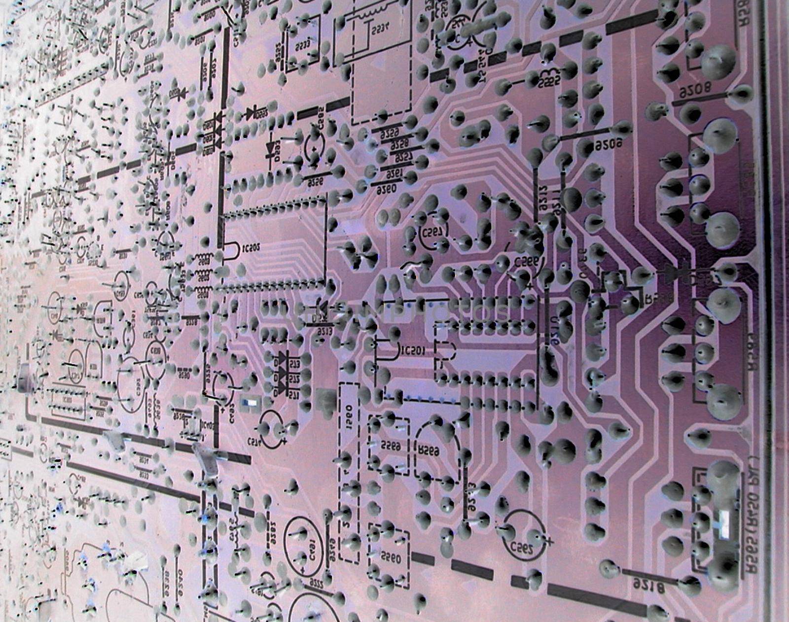 Abstract close up of the circuitry within a large, complex purple electronic motherboard.