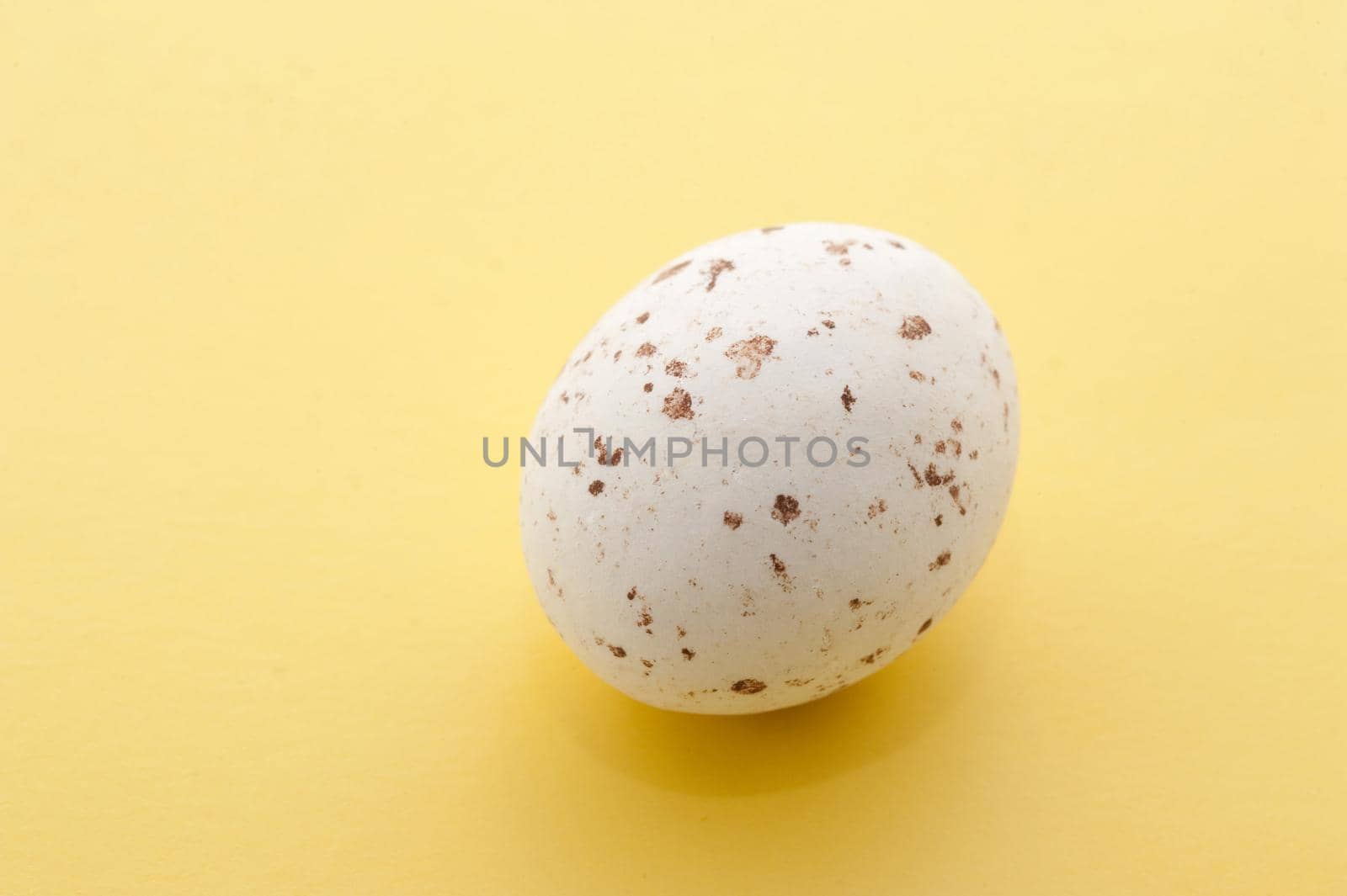 Single Speckled Mini Easter Egg on a yellow background