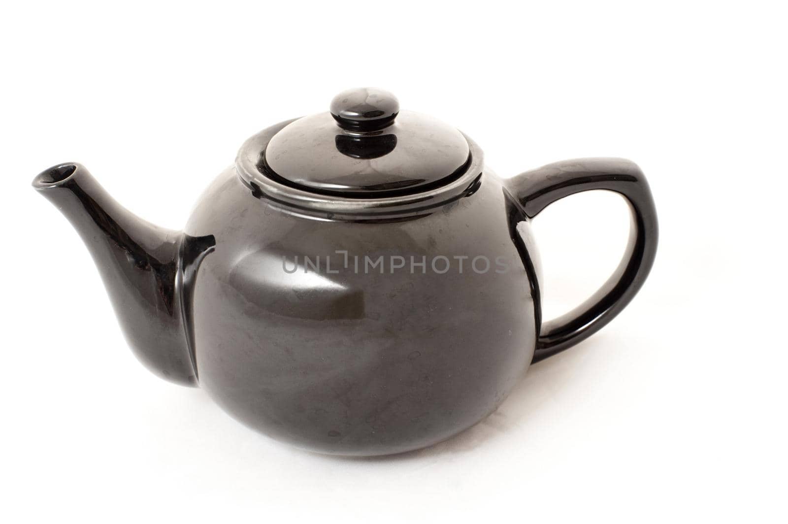 Shiny isolated bulbous ceramic teapot for serving and brewing tea, side view on white