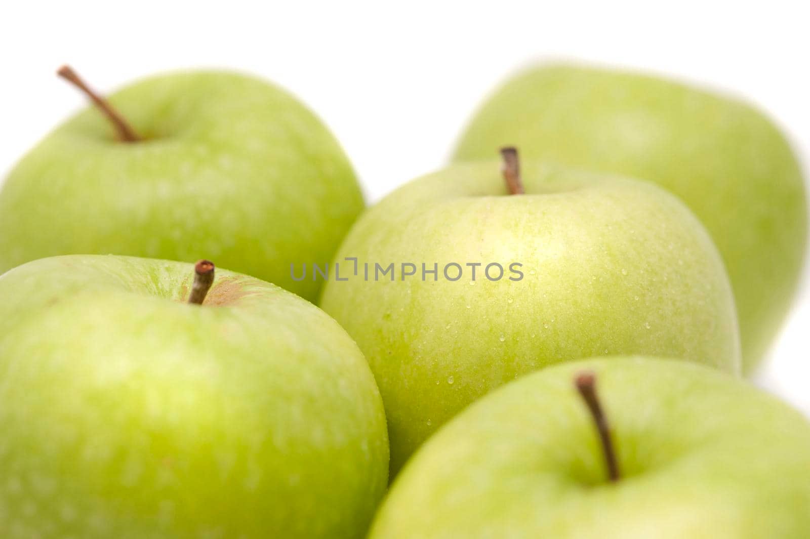 Close up of a group of crisp healthy fresh green apples over a white background
