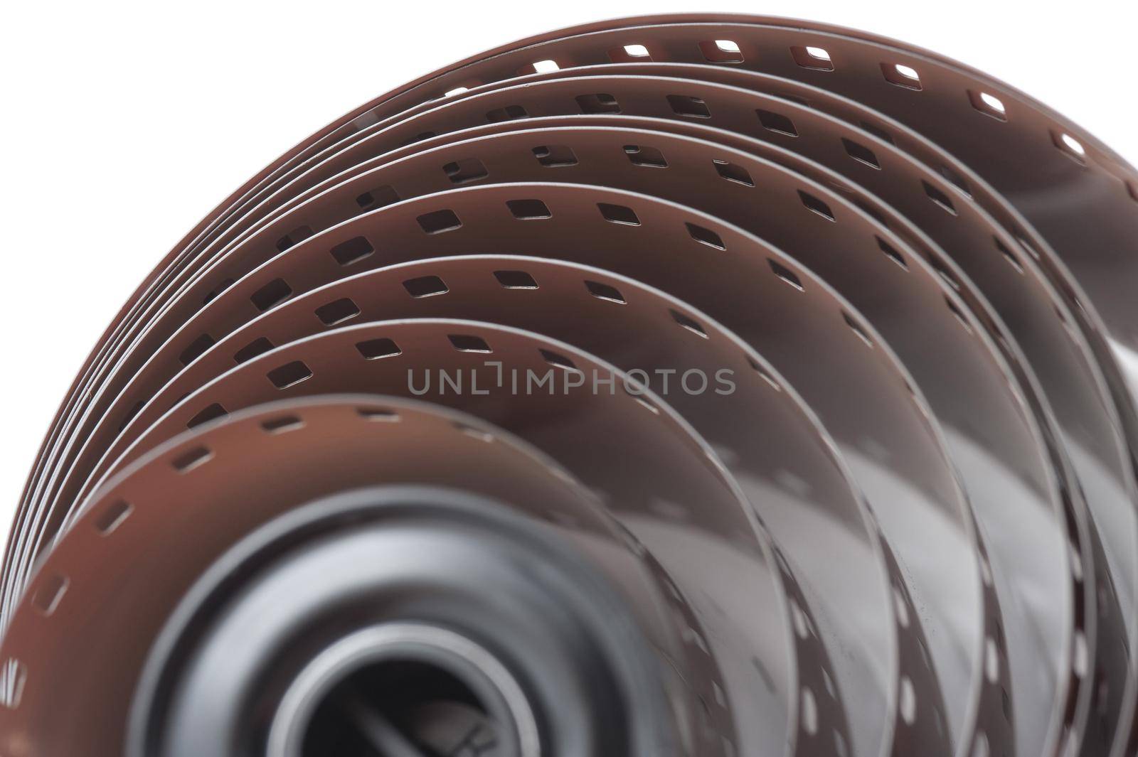 Extreme top down close up of uncoiled roll of 35 millimetre film over white background