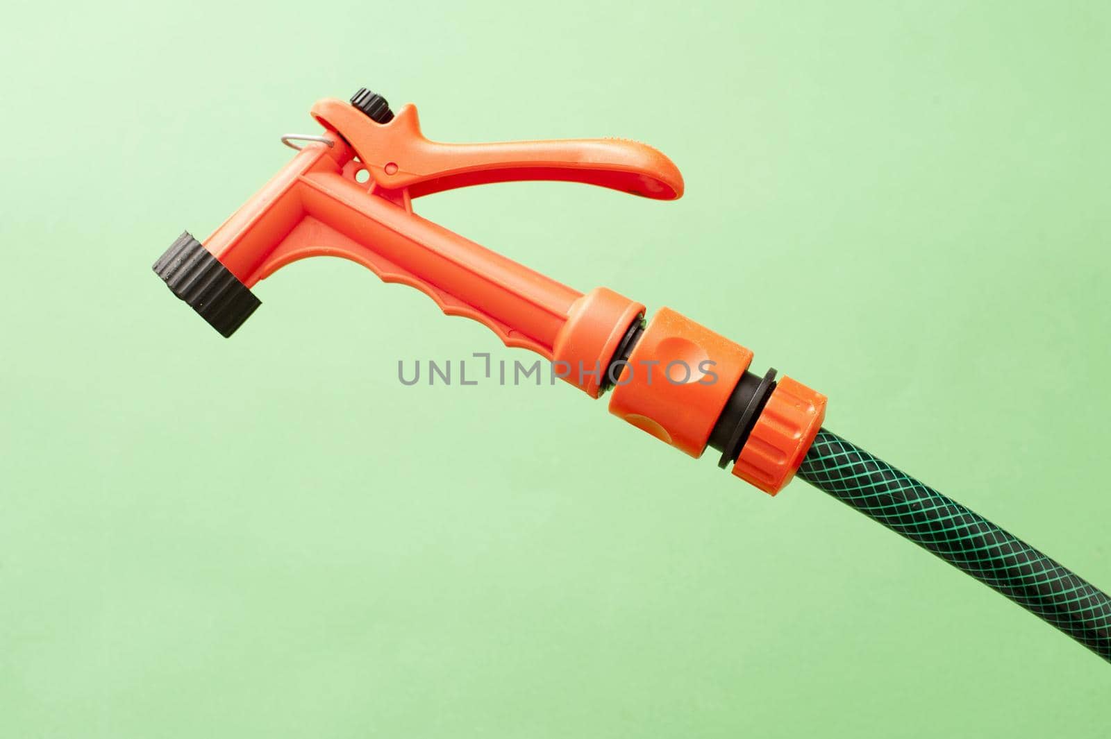 Orange plastic garden spray nozzle on the end of a hosepipe for watering delicate seedlings and seed beds