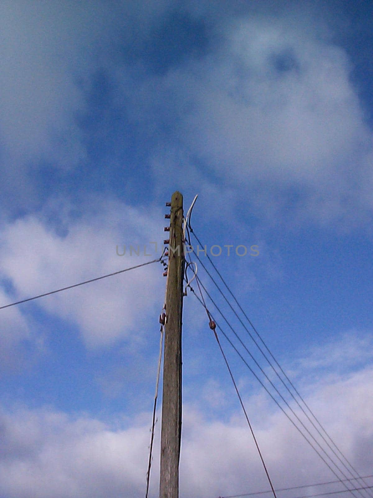 Low angle view looking up at a wooden telephone pole