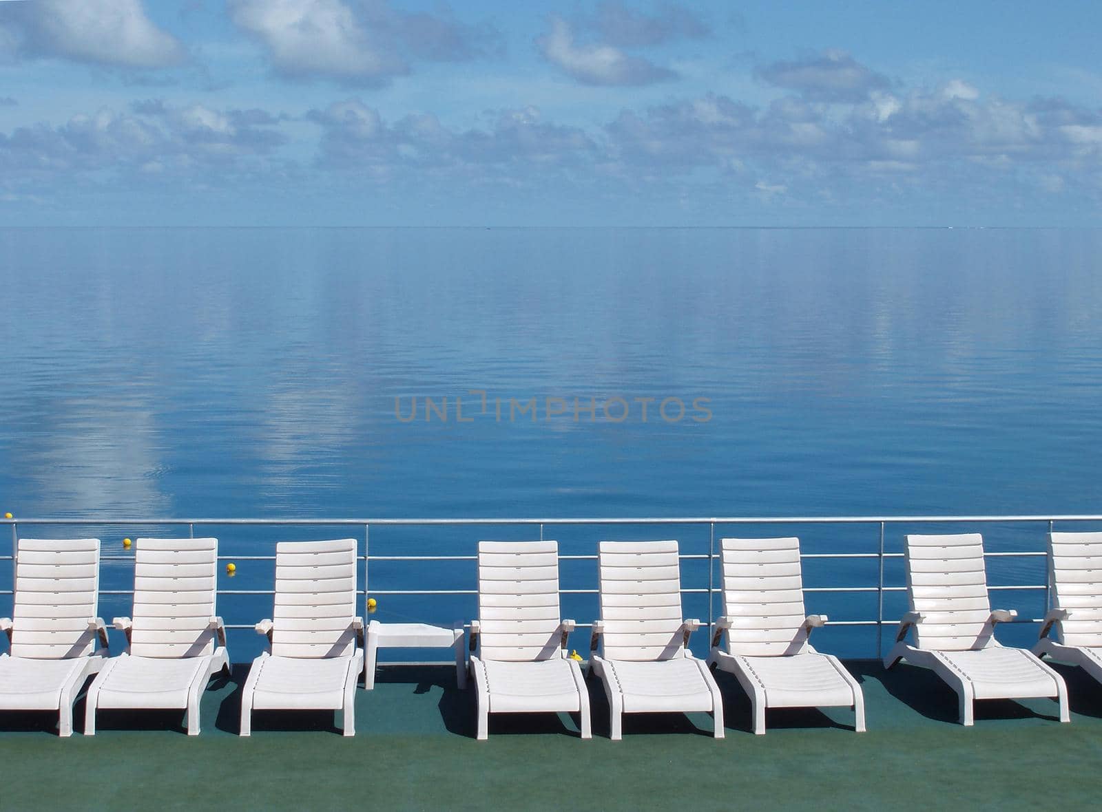 a line of sun loungers and still blue water, great barrier reef, australia