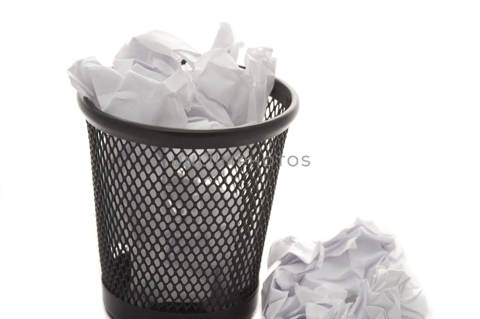 Mini wastepaper basket full to overflowing with crumpled white paper