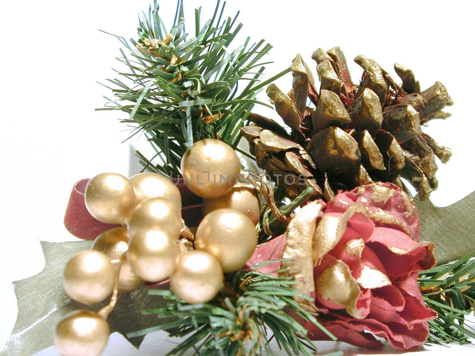 Pine cone Christmas decoration with a red rose, gold berries and green foliage to decorate the Xmas tree or table for dinner