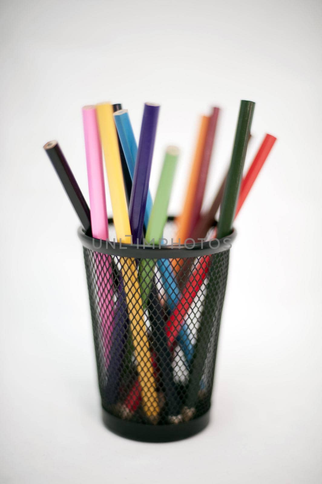 Coloured pencil crayons in a container for use in sketching, drawing and colouring in