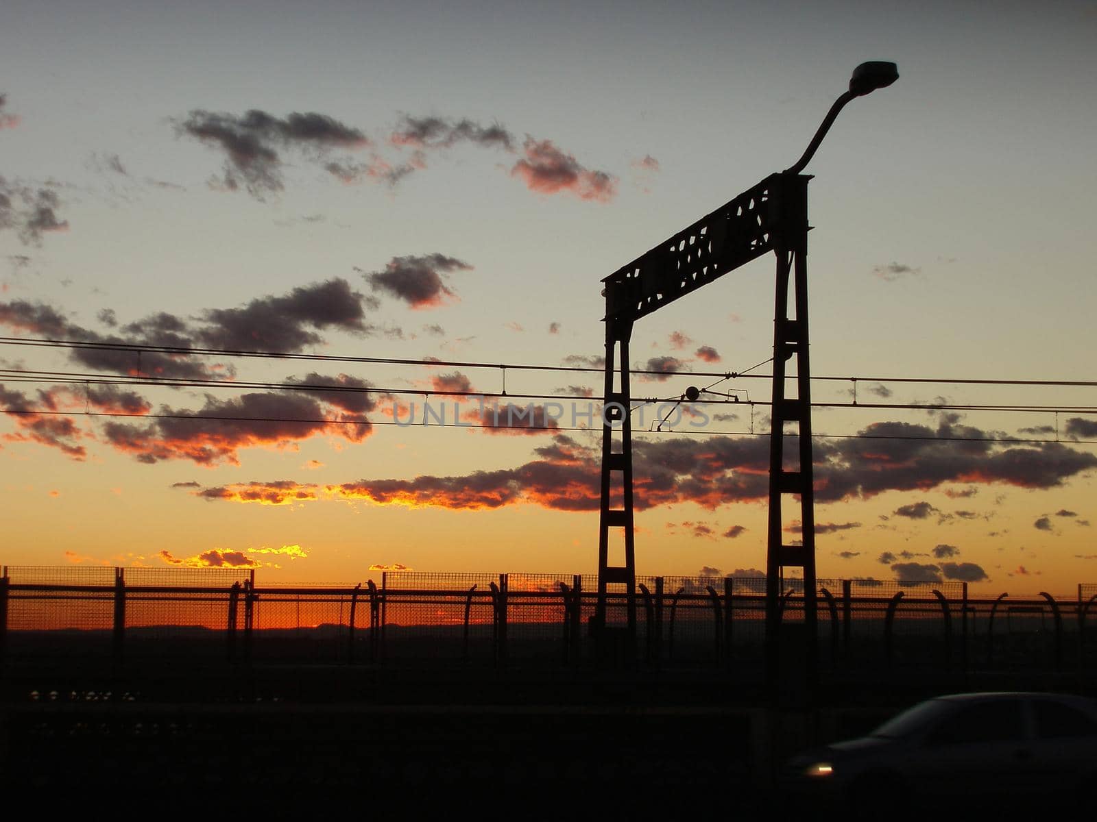 a beautiful orange sunset and silhouette of passing traffic