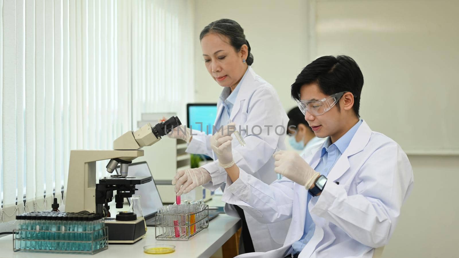 Professional scientist team conducting experiment in laboratory. Medicine and science research concepts.