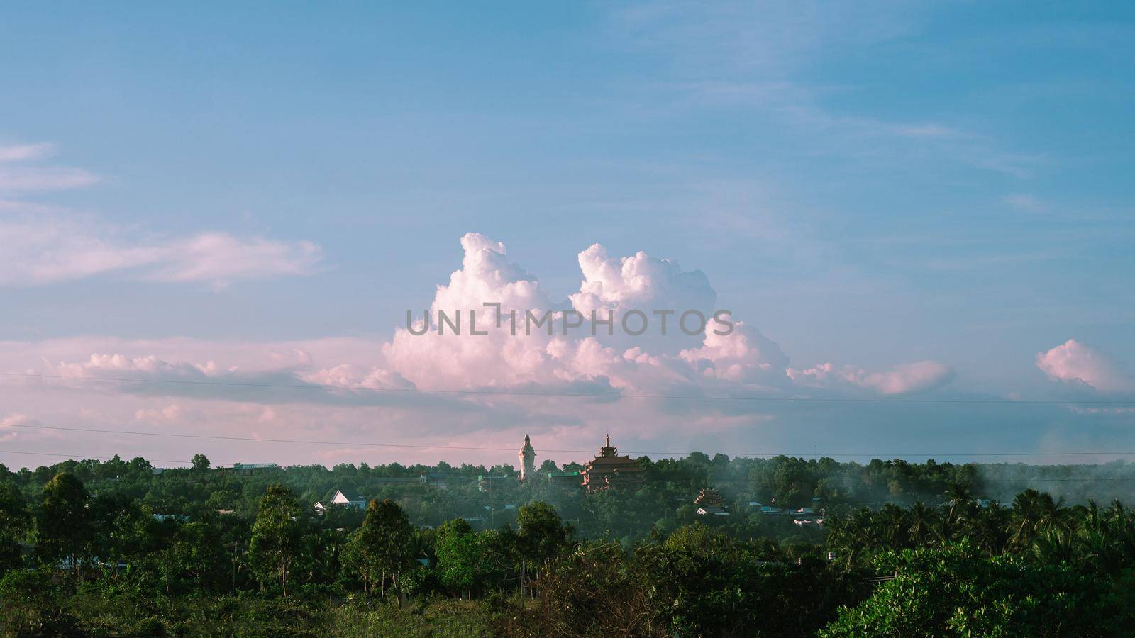 Atmosphere panorama cumulus white clouds over buddhist temple statue. Dramatic Sky Sunset Meditation background.