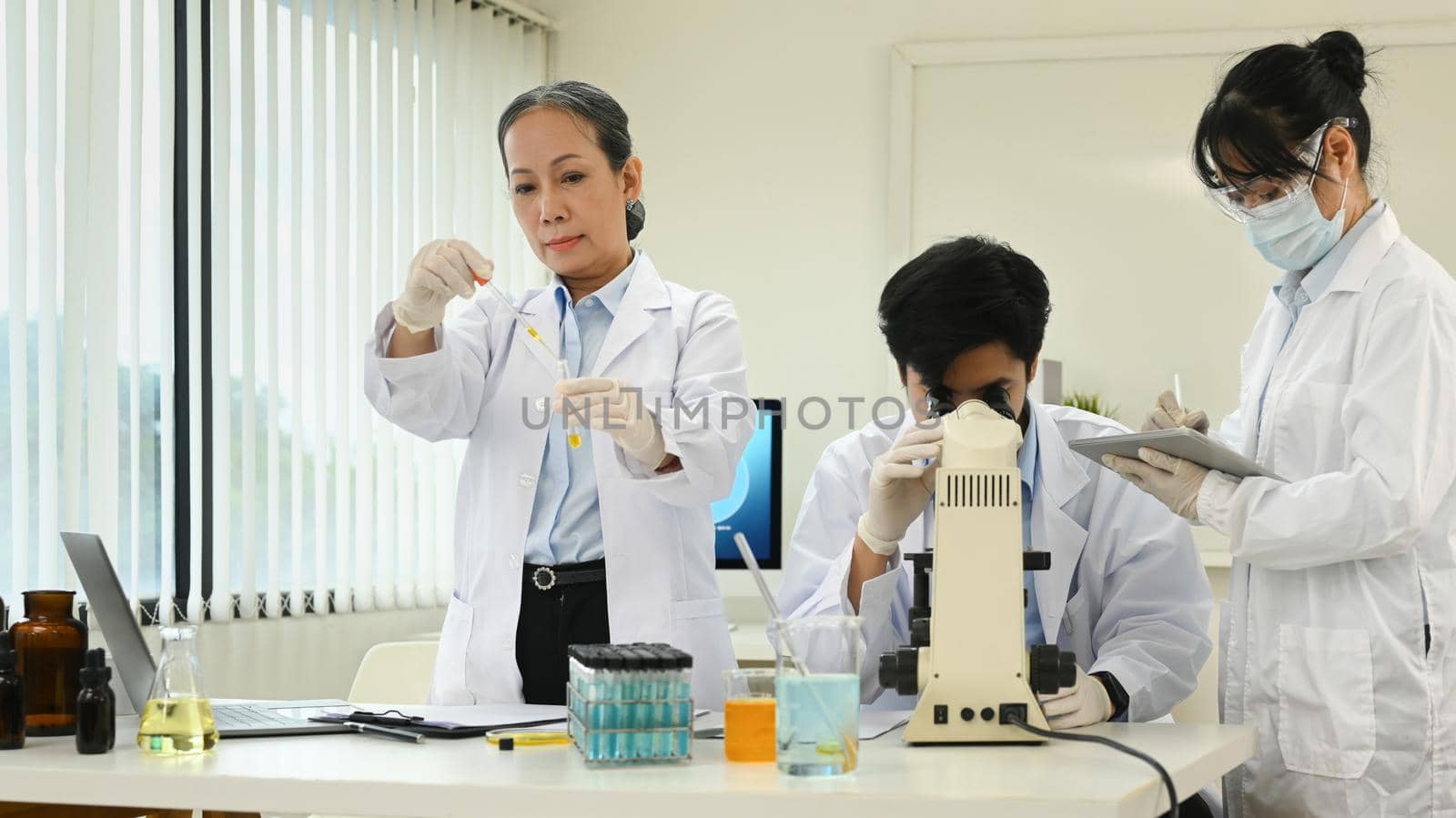 Professional scientist team conducting experiment in laboratory. Medicine and science research concepts.